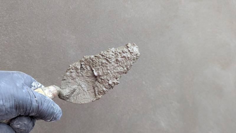 Plaster trowel held against a freshly skimmed wall